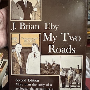 May include: A brown book cover with the title "My Two Roads" by J. Brian Eby. The cover features a photo of three men in suits and a photo of four men in a field. The book is a second edition and describes itself as "More than the story of a geologist - the account of a tireless observer of people."