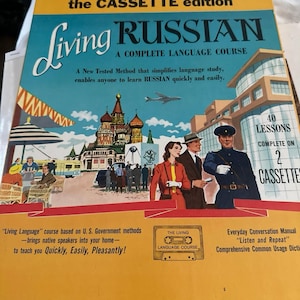 Op de afbeelding: Vintage "Living Russian" taaltraining boekcover. De cover toont een retro illustratie met de titel in groot schrift, een stadsgezicht en figuren. De tekst belooft een complete taalcursus met 40 lessen op 2 cassettes.
