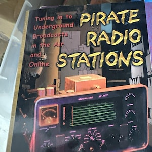May include: A book titled "Pirate Radio Stations" with a vintage radio illustration. The cover features the text "Tuning in to Underground Broadcasts in the Air and Online." The author's name, Andrew Yoder, is at the bottom.