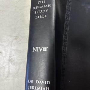 May include: A black leather-bound book titled "THE JEREMIAH STUDY BIBLE" with the NIV logo and the author's name, Dr. David Jeremiah, in white lettering. The spine features an embossed geometric pattern.