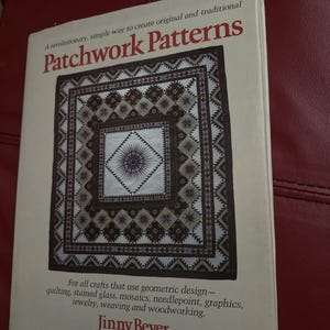 May include: A book titled "Patchwork Patterns" with a geometric quilt design on the cover. The cover text includes "A revolutionary, simple way to create original and traditional" and "For all crafts that use geometric design". The author's name, Jinny Beyer, is also visible.