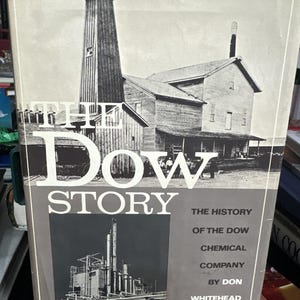 May include: A vintage book cover with a black and white photo of a factory building and the text "THE DOW STORY THE HISTORY OF THE DOW CHEMICAL COMPANY BY DON WHITEHEAD".