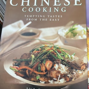 Puede incluir: Un libro de cocina titulado "Classic Chinese Cooking" con el subtítulo "Tempting Tastes From The East". La portada presenta una foto de un plato chino con arroz, verduras y carne. El nombre de la autora, Linda Doeser, está en la parte inferior.