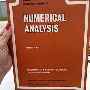 May include: A vintage orange book titled "Schaum's Outline Series: Theory and Problems of Numerical Analysis" by Francis Scheid. The book includes 775 solved problems and is part of the Schaum's Outline Series in Mathematics, published by McGraw-Hill Book Company.