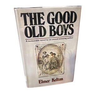 May include: A paperback book titled "THE GOOD OLD BOYS" with black text on a light background. The cover features an illustration of men in hats and a decorative border. The author's name, Elmer Kelton, is at the bottom.