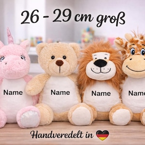 May include: Four plush stuffed animals including a pink unicorn, a tan teddy bear, a brown lion, and a giraffe, each featuring a white belly patch with the word Name printed on it. The text 26 - 29 cm groß is visible above the toys.