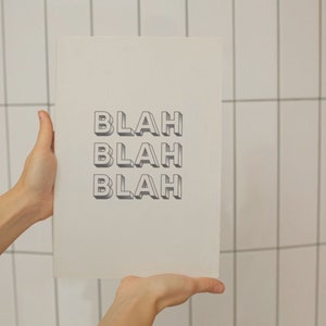 May include: A white poster with the word "Blah" repeated three times in a 3D style font.