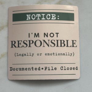 Może przedstawiać: Kwadratowa, beżowa karta z czarnym tekstem: "NOTICE: I'M NOT RESPONSIBLE (Prawnie lub emocjonalnie) Documented &bull; File Closed". Słowo "NOTICE" znajduje się w zielonym prostokącie.
