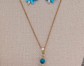 May include: A gold-coloured necklace and earring set featuring turquoise starfish pendants and beads. The necklace has a delicate chain with a pendant of turquoise beads, white pearls, and a starfish. The earrings mirror the pendant design.