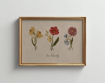 May include: A framed print featuring watercolor illustrations of three different flowers in yellow, red, and pink hues. The text "Our Family" is written below the flowers in cursive script. The frame is gold.