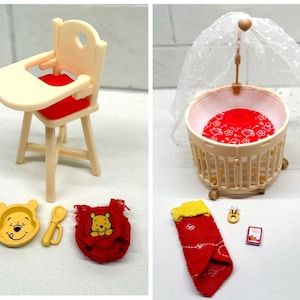 May include: A collection of miniature Winnie the Pooh themed nursery items. Includes a high chair with a red seat, a crib with a canopy, a bowl, spoon, bib, and a sleeping bag. The items are in shades of yellow, red, and cream.