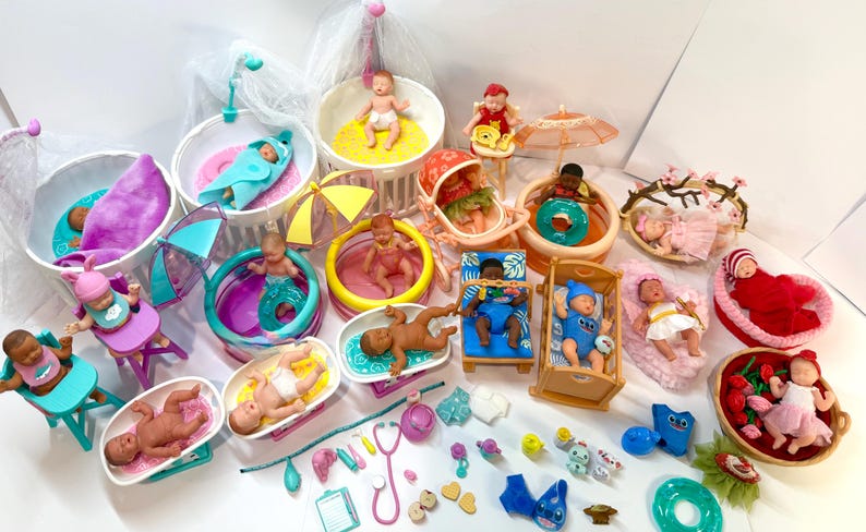 May include: A collection of miniature baby dolls in various settings, including bathtubs, beds, and pools. The dolls are in different poses and outfits, with accessories like umbrellas and toys. The color palette includes pink, blue, yellow, and white.