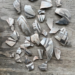 May include: A set of three ceramic mugs with a speckled, matte finish. The mugs are in shades of cream, light gray, and dark gray. Each mug has a simple, minimalist design, perfect for coffee or tea.