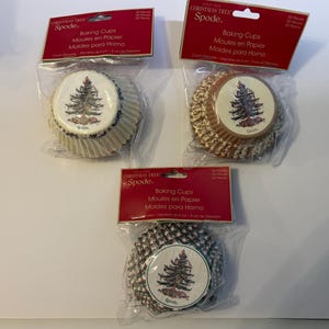 May include: Three packages of Spode Christmas Tree baking cups, each containing 50 pieces. The cups feature a 2-inch diameter and a festive tree graphic. The packaging is clear plastic with red headers displaying the brand name and product details.