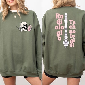 May include: Green sweatshirt with a skeleton holding a coffee cup on the front and the text "Radiologic Technologist" with a spine graphic on the back.