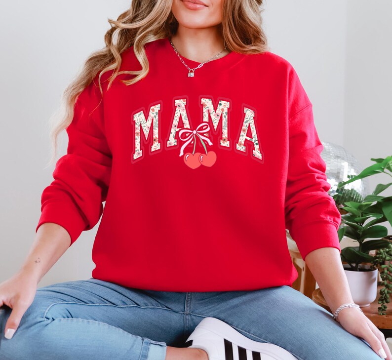 Może przedstawiać: Czerwona bluza z nadrukiem "MAMA" w kwiatowym wzorze i dwiema wiśniami z kokardką.