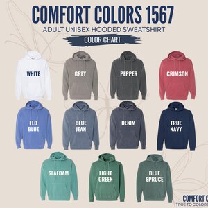 K&ouml;nnte beinhalten: Eine Comfort Colors 1567 Unisex-Kapuzenpullover-Farbkarte mit elf Hoodies in Wei&szlig;, Grau, Pfeffer, Karmesinrot, Flo-Blau, Jeansblau, Denim, Marineblau, Meerschaum, Hellgr&uuml;n und Fichtenblau, jeweils mit den entsprechenden Textbeschriftungen.