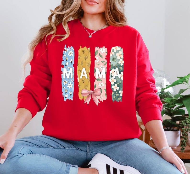 Pu&ograve; includere: Felpa rossa con un design floreale e la parola "MAMA" stampata sul davanti.