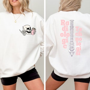 May include: White sweatshirt with a skeleton holding a coffee cup on the front and the words "Radiologic Technologist" with a spine graphic on the back.