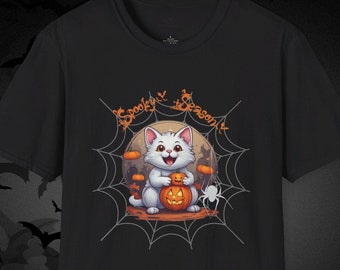 Puede incluir: Camiseta negra con un gato de dibujos animados sosteniendo una calabaza de Halloween. El gato está dentro de una telaraña con las palabras "Spooky Season" arriba. El diseño incluye calabazas y una araña.