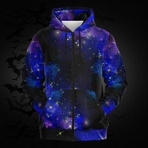 May include: A zip-up hoodie featuring a vibrant galaxy design in shades of blue, purple, and black. The celestial pattern includes stars and nebulas, creating a cosmic aesthetic. The hoodie has a hood and two front pockets.