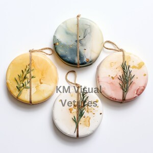 May include: Four round decorative ornaments with marbled designs in shades of yellow, blue, pink, and white. Each ornament is adorned with a sprig of greenery and tied with twine. Gold flecks add a touch of sparkle. The text "KM Visual Vetices" is visible.