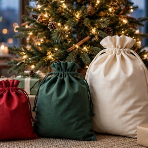 Peut inclure: Trois sacs en tissu avec cordon de serrage, de couleur rouge, vert foncé et blanc cassé. Chaque sac présente un haut froncé avec des liens assortis, offrant un mécanisme de fermeture simple pour ranger des objets divers.