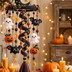 May include: A hanging mobile featuring a black crocheted crescent moon at the top, adorned with small yellow stars and green leaves. Dangling elements include white ghosts, orange jack-o'-lanterns, black bats, and yellow stars, all connected by beads and a central spiral.