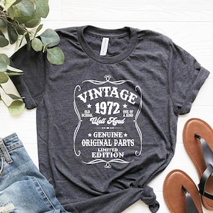 May include: Gray t-shirt with a vintage-style graphic that says "Vintage 1972 Old School Well Aged One of a Kind Genuine Original Parts Limited Edition".