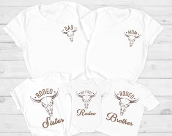 May include: White t-shirts with a brown skull design and text that says "Dad", "Mom", "Rodeo Sister", "My First Rodeo", and "Rodeo Brother".