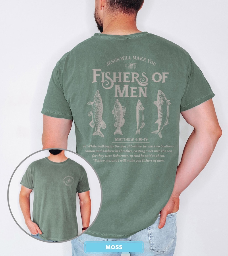 May include: A moss green t-shirt with the text "JESUS WILL MAKE YOU FISHERS OF MEN" and four fish illustrations. The text "MATTHEW 4:18-19" is below the fish illustrations. The shirt also has a small circular graphic on the front.