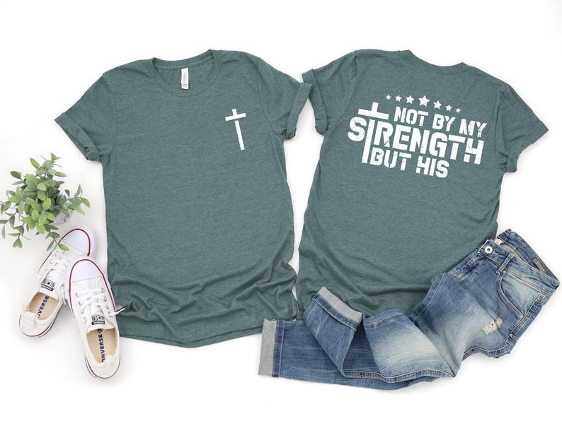 May include: A teal green t-shirt with a cross on the front and the text "Not by my strength but his" on the back.
