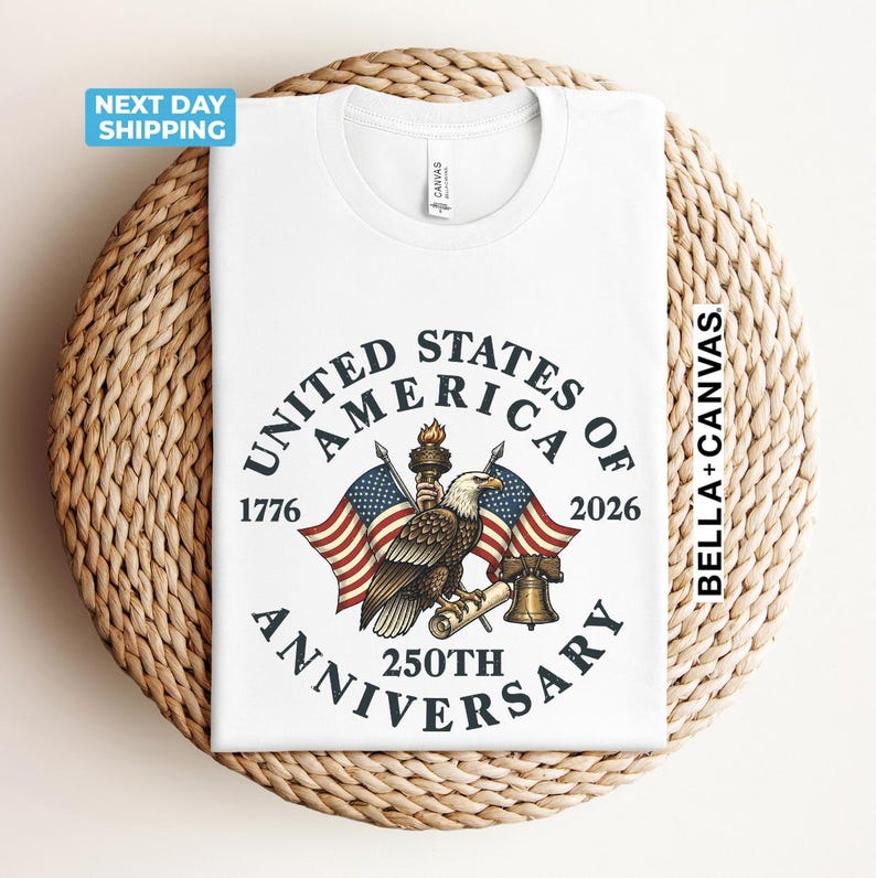 May include: White t-shirt featuring a patriotic design for the 250th anniversary of the United States of America. The design includes an eagle, American flags, and the text "United States of America 250th Anniversary".