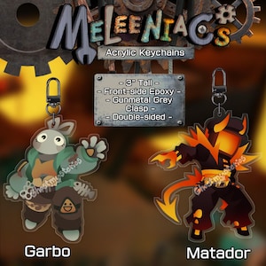 May include: Acrylic keychains featuring two character designs: "Garbo," a rabbit-like figure in green and brown, and "Matador," a fiery demon. Each keychain is 3 inches tall, double-sided, with front-side epoxy and a gunmetal grey clasp.