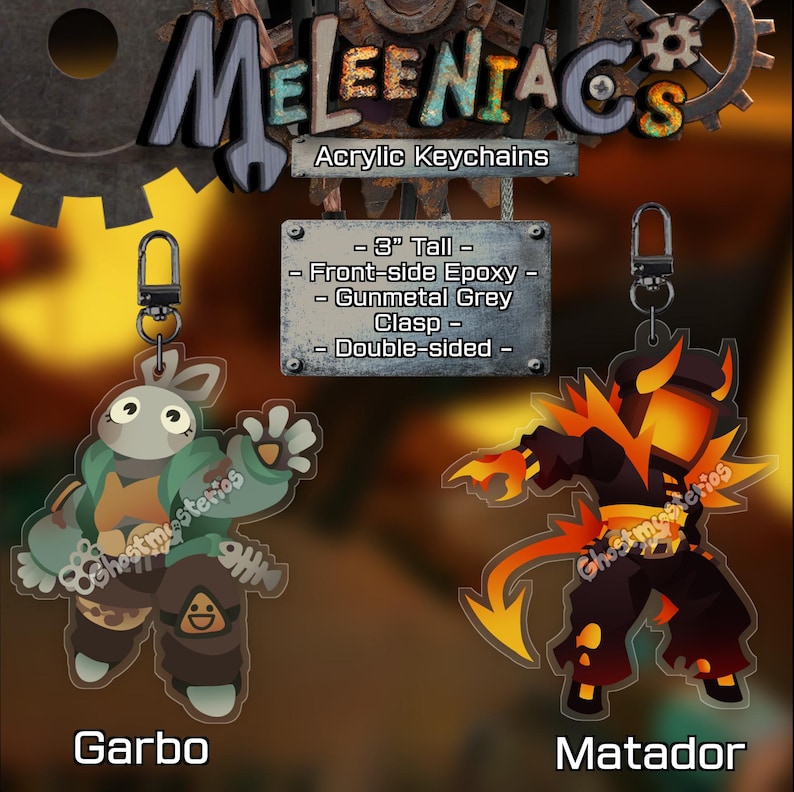 May include: Acrylic keychains featuring two character designs: "Garbo," a rabbit-like figure in green and brown, and "Matador," a fiery demon. Each keychain is 3 inches tall, double-sided, with front-side epoxy and a gunmetal grey clasp.