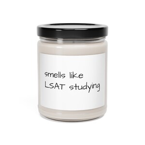 May include: A glass jar with a black lid and a white label that reads "smells like LSAT studying".