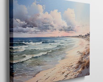 May include: A canvas print of a beach scene. The artwork depicts a sandy beach with footprints, rolling waves, and a cloudy sky. The colors are soft, with blues, pinks, and tans dominating the scene. The artwork is mounted on a wooden frame.