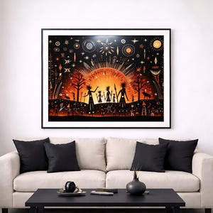 May include: A framed art print showing a tribal scene in a stylized manner. The artwork features silhouetted figures against a vibrant orange and black background, with a central sunburst design. The print is displayed above a cream-coloured sofa with black cushions.