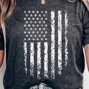 May include: A grey t-shirt with a white distressed American flag design.