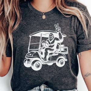Big Foot Golf Cart Unisex T-Shirt, Sasquatch Friedenszeichen Shirt, lustiges Cryptid Tshirt, Natur Liebhaber Geschenk, Fabelwesen Top