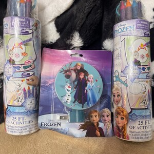 May include: Two cylindrical activity sets and a nightlight featuring characters from Disney's Frozen. The activity sets include crayons and a sticker roll with 25 feet of printed pages. The nightlight has a round design with the Frozen characters.