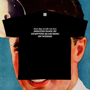 May include: Black t-shirt with white text that reads "that dog inside me has INDUCED PANIC BY SYMPTOM SEARCHING ON WEBMD."