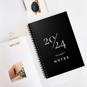 Puede incluir: Cuaderno negro de espiral con el texto "2C/24" y "NAME" NOTES en letras blancas.