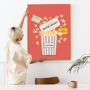 K&ouml;nnte beinhalten: Ein rotes Poster mit einem gestreiften Popcorn-Eimer und Popcorn, das herausf&auml;llt. Das Poster zeigt auch Tickets mit der Aufschrift "Eintritt f&uuml;r den Filmabend" und "Freier Eintritt".