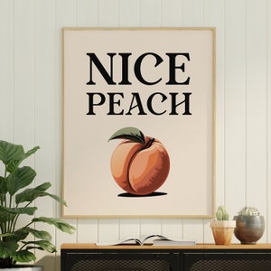 May include: A white framed print with the text "NICE PEACH" in black lettering. A peach with a green leaf is illustrated below the text.