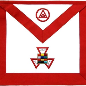 Puede incluir: Delantal blanco masónico con ribete rojo y símbolos bordados. El delantal presenta un círculo rojo con un triángulo y una brújula en su interior, y una estrella de tres puntas con un cuadrado en el centro.