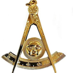 May include: A gold-colored Masonic compass and square with a sun and face design in the center. The compass and square are joined together at the top with a ring.
