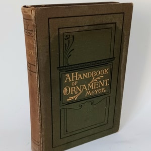May include: A vintage brown and green hardcover book titled "A Handbook of Ornament. Meyer."