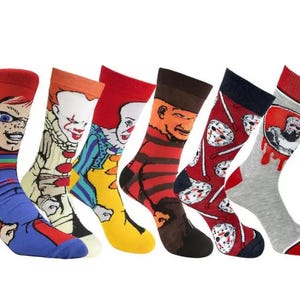 May include: Set of six colorful socks featuring various horror movie characters. The socks are red, blue, yellow, black, gray, and white with graphic prints of Freddy Krueger, Jason Voorhees, Pennywise, Chucky, and Michael Myers.