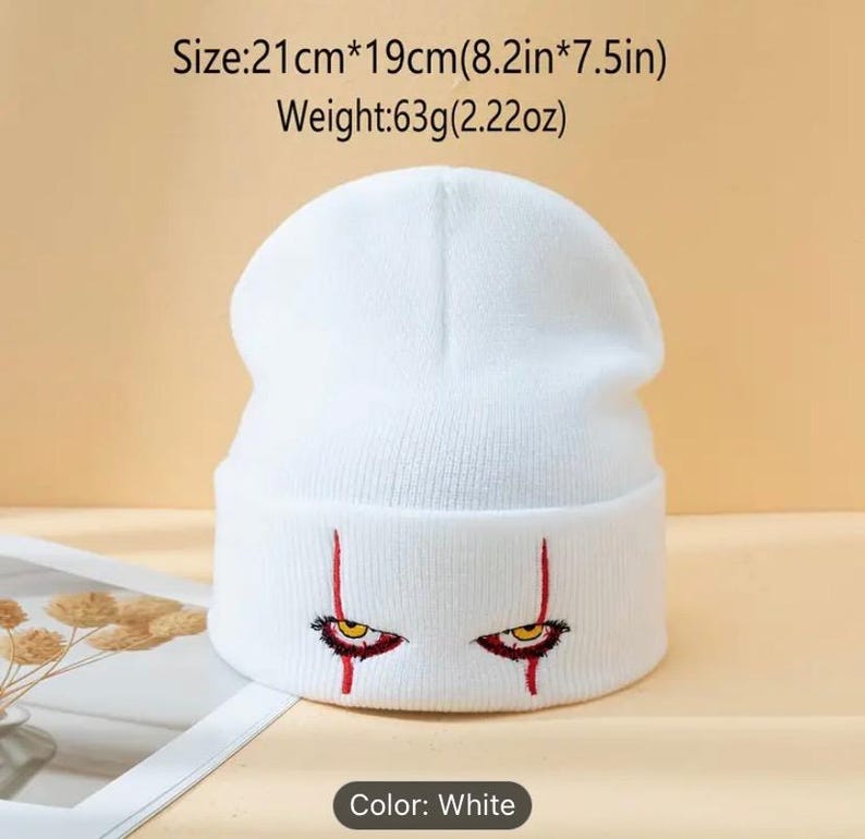 May include: White knit beanie with red embroidered eyes and red lines. Size: 21cm x 19cm (8.2in x 7.5in). Weight: 63g (2.22oz).